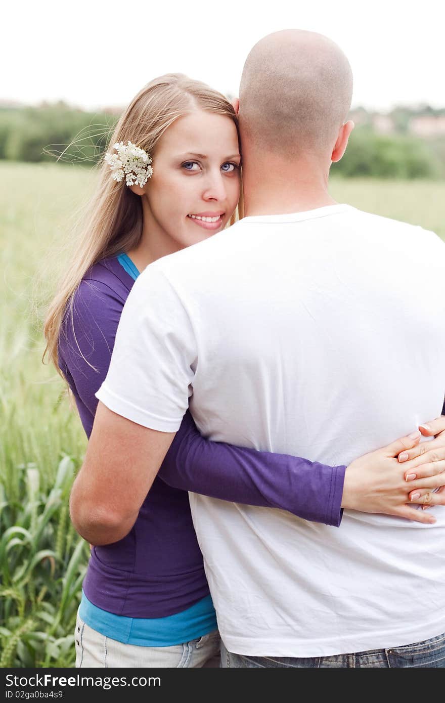 Honeymoon couple hugging each other, woman looking at us outdoor