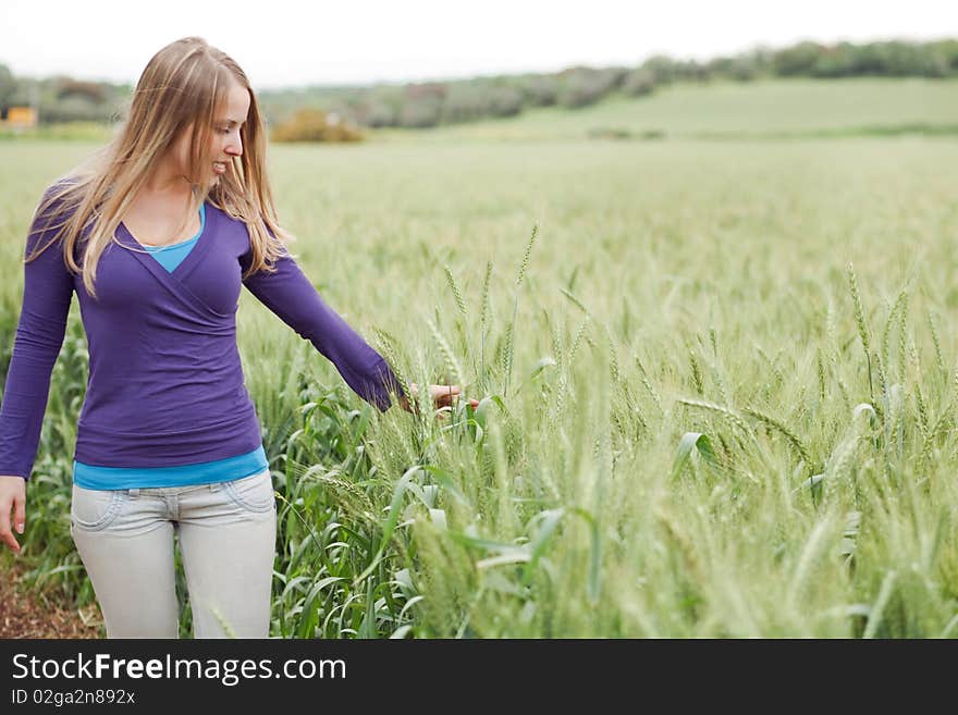 Portrait of lady walking between the grass in the field