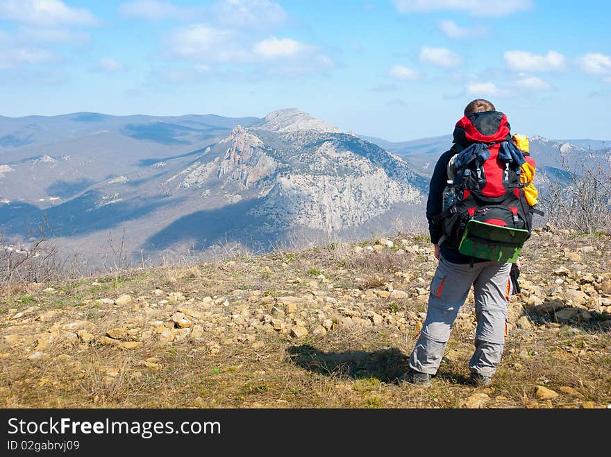 Hiker on a peak enjoys mountain landscape