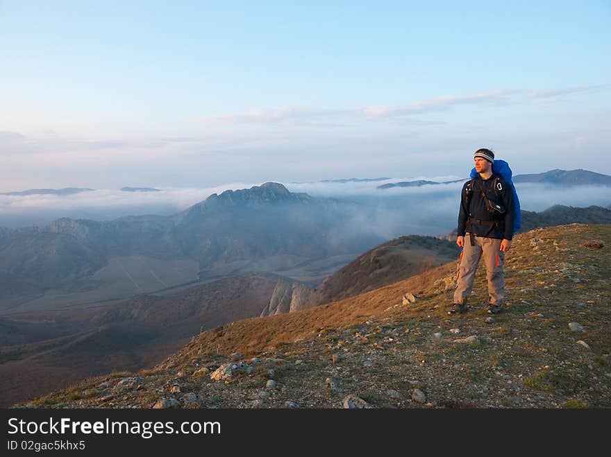 Hiker on a peak enjoys mountain landscape