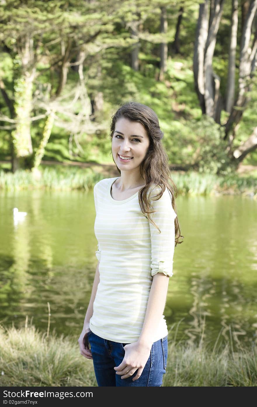 Portrait of a Pretty Young Woman Standing in a Park. Portrait of a Pretty Young Woman Standing in a Park