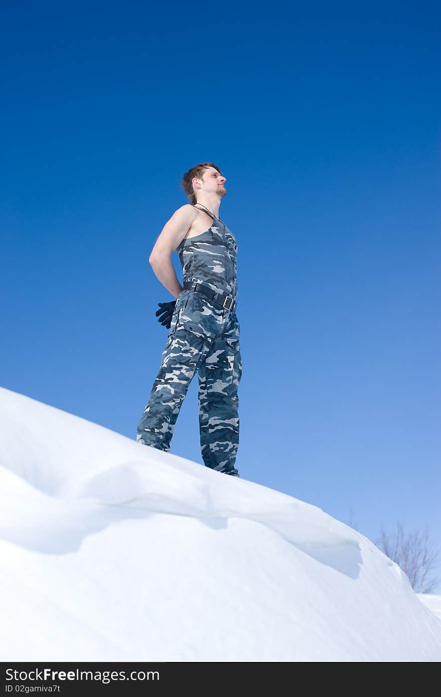 Man in camouflage clothing on the edge of the cliff