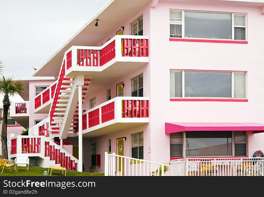 Pink colored motel with red stairs and balconies. Pink colored motel with red stairs and balconies