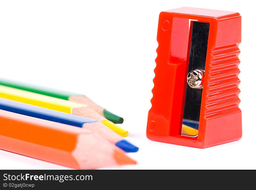 Colorful pencil and red sharpener on white background