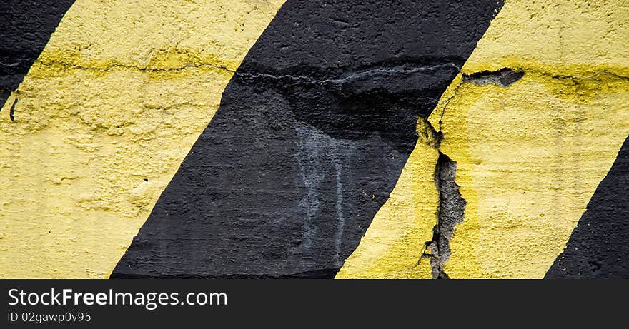 Yellow and black old emergency lines on concrete wall