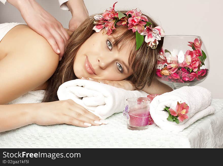 Beautiful woman on massage table with flower in hair