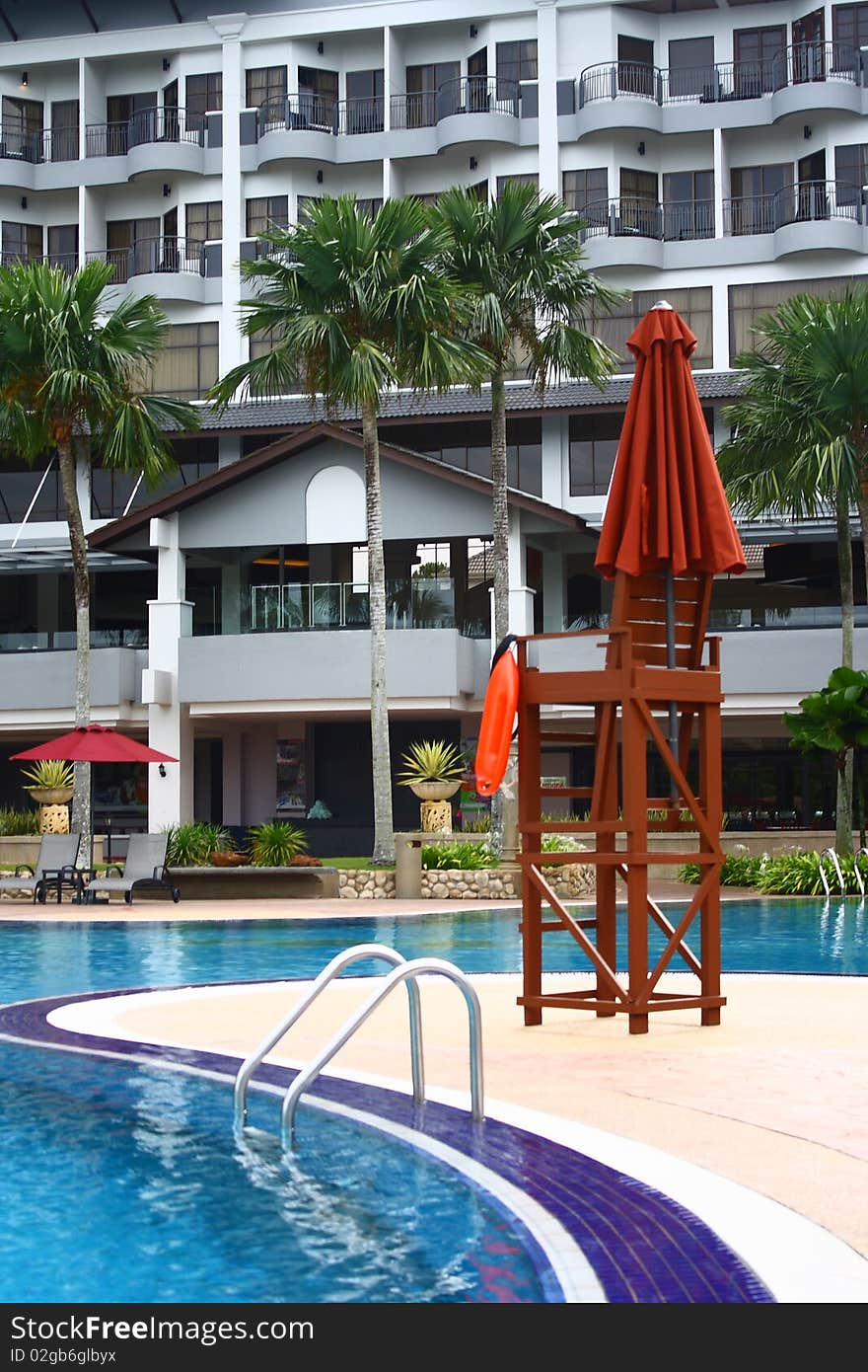 An image showing a lifeguard chair at a poolside of a luxury hotel. An image showing a lifeguard chair at a poolside of a luxury hotel