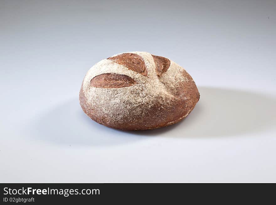 Loaf of bread with grains on a white background