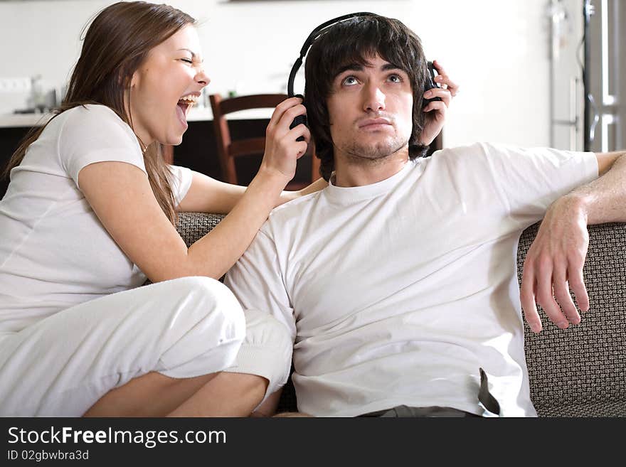 Boy in headphones with girl on sofa