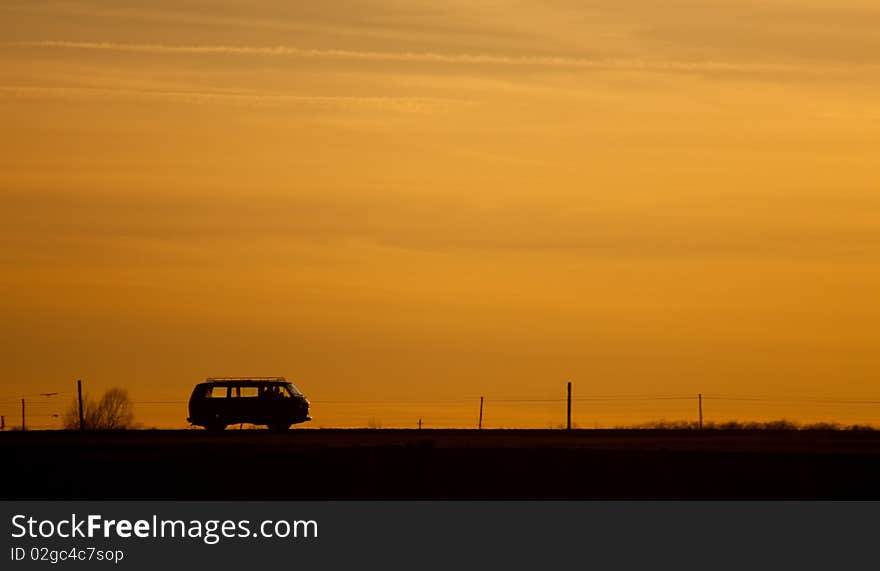 Car silhouette on the road in the sunset