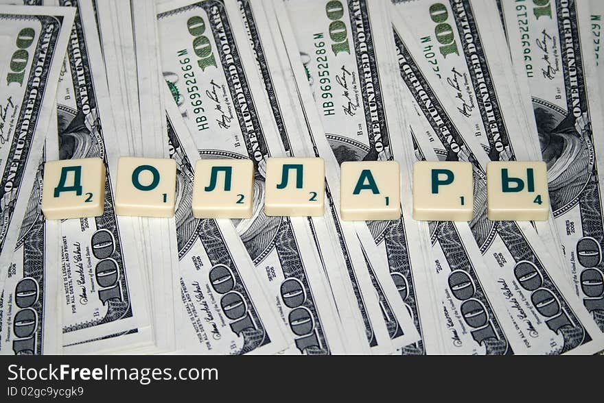 A bundle of money with denominations of one hundred dollars and an inscription in Russian dollars