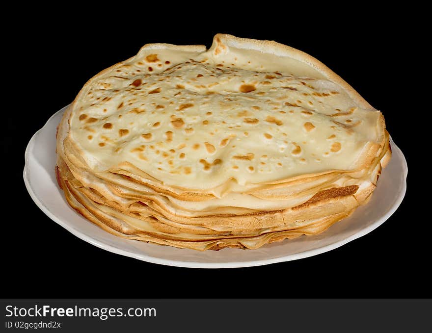 Pancakes on a white dish and on a black background