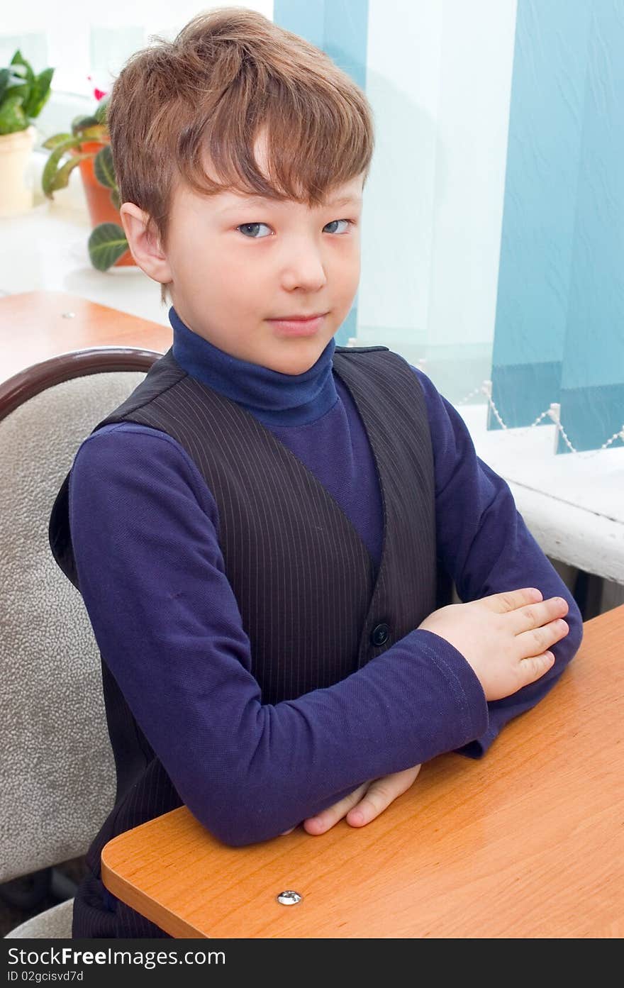 The pupil sits at a school desk. School