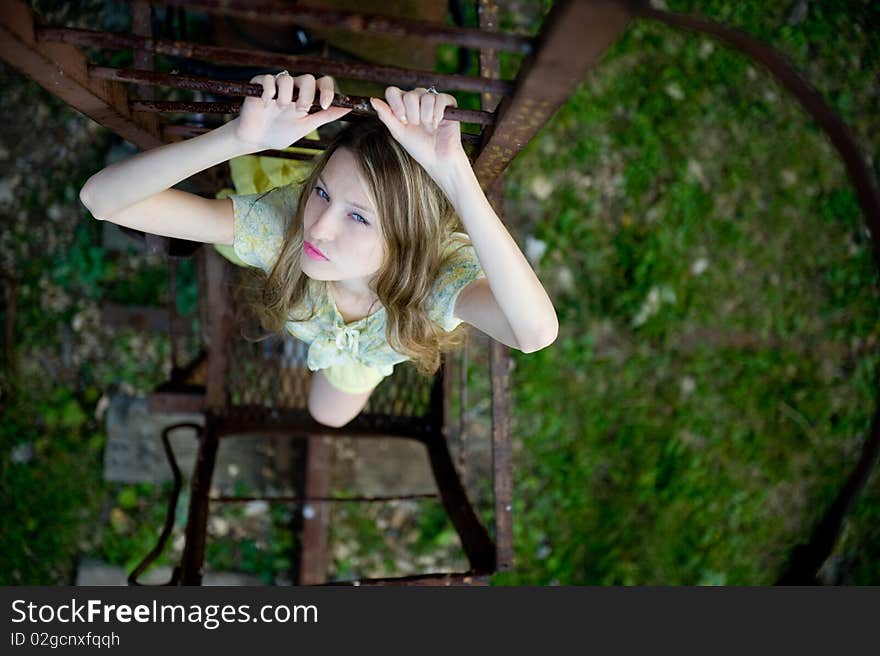 Young woman standing on a rust ladder