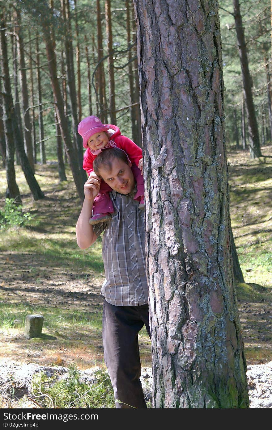 Father and daughter for a walk in a pine forest