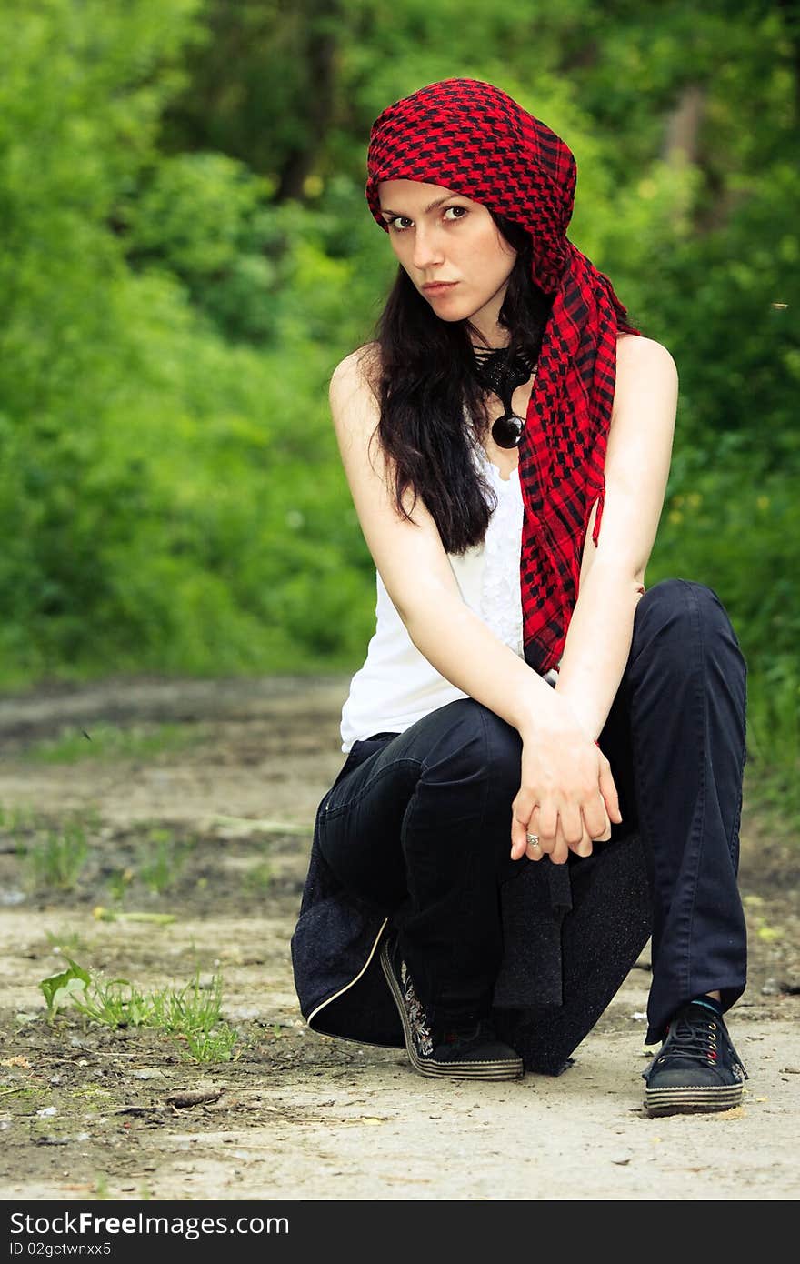 Girl sitting in the forest, on his head wearing a red kerchief. Girl sitting in the forest, on his head wearing a red kerchief