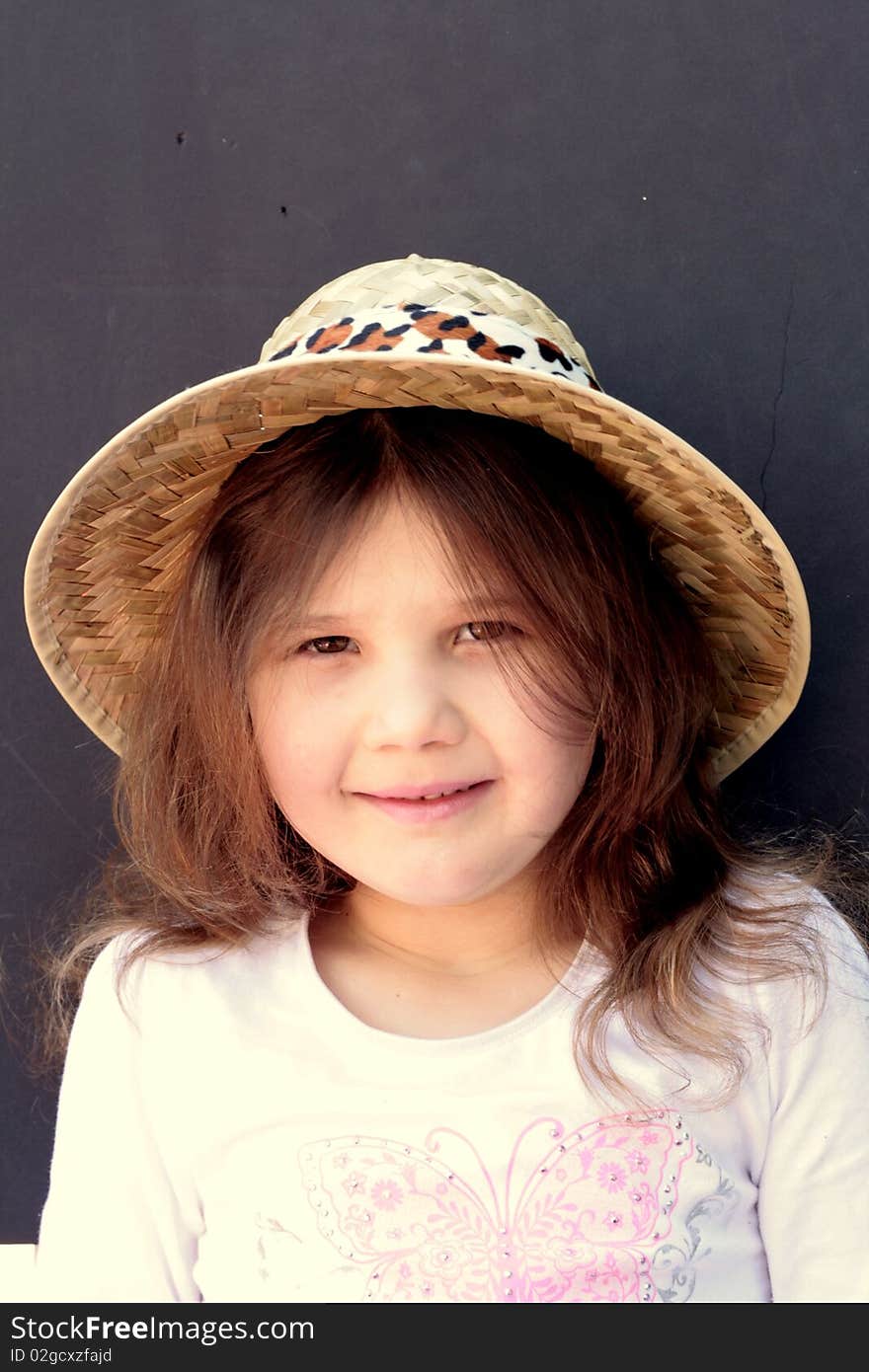 Happy little girl wearing straw hat and white blouse, copy space available