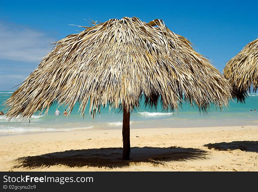 Parasol made out of palm leafs on beach.