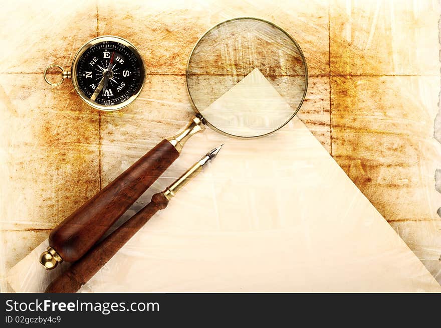 Compass and magnifier on old textured paper