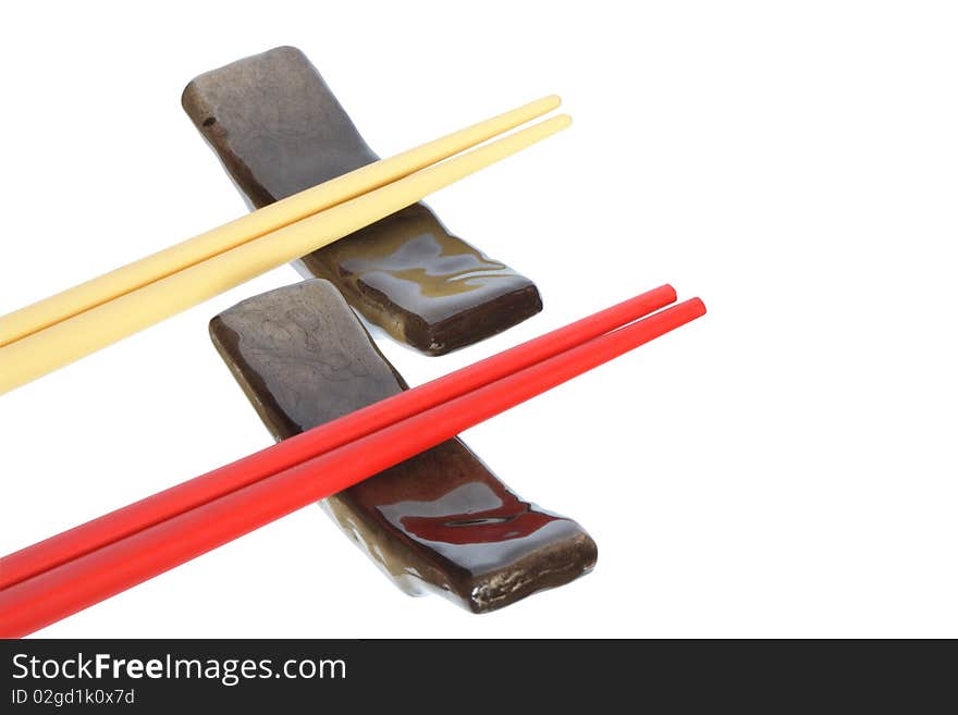 Two pair of colored chopsticks lying on rests. Isolated on white with clipping path