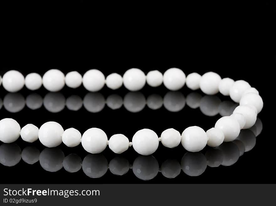 White beads on black background