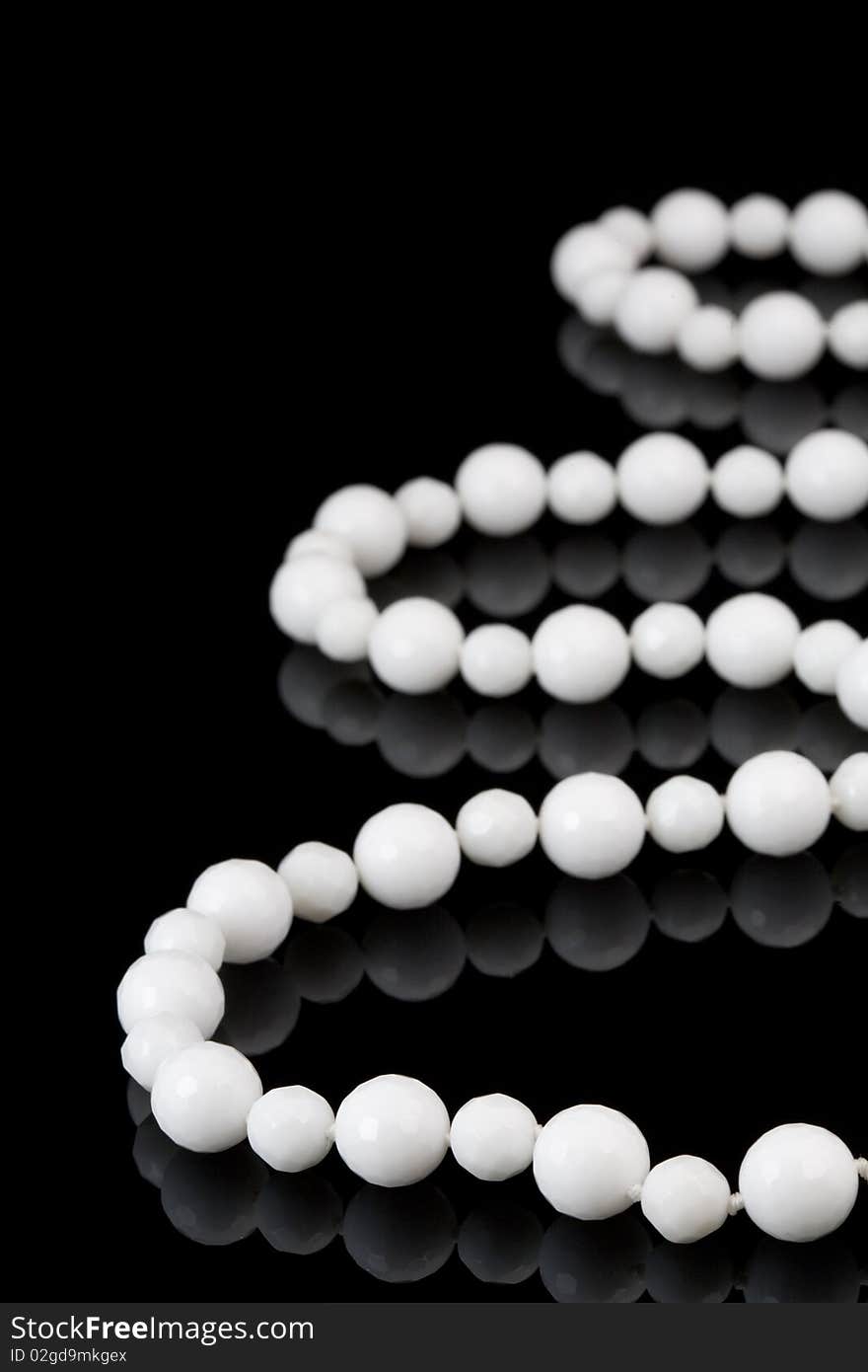 White beads on black background