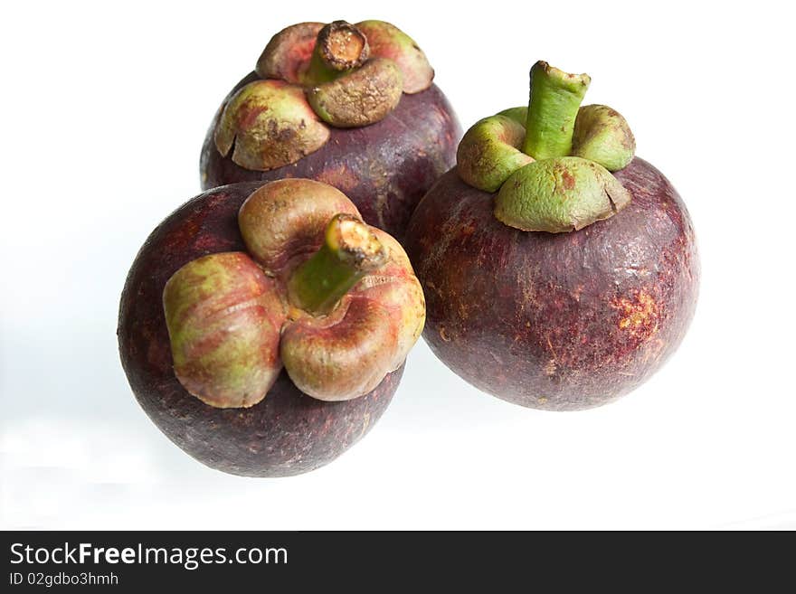 Three mangosteens isolated against a white background