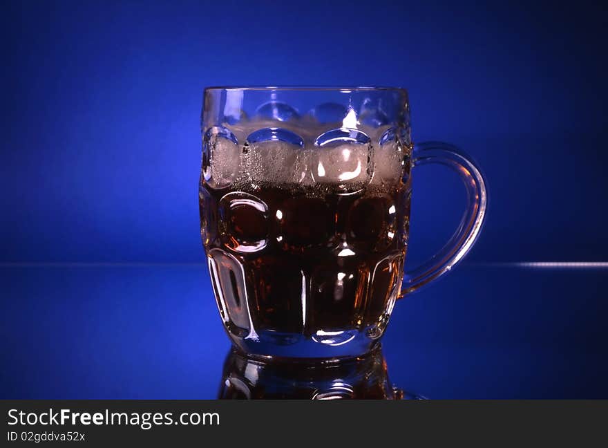 A glass of beer isolated on blue background