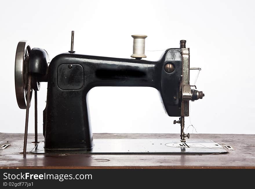 Old black sewing machine on white background