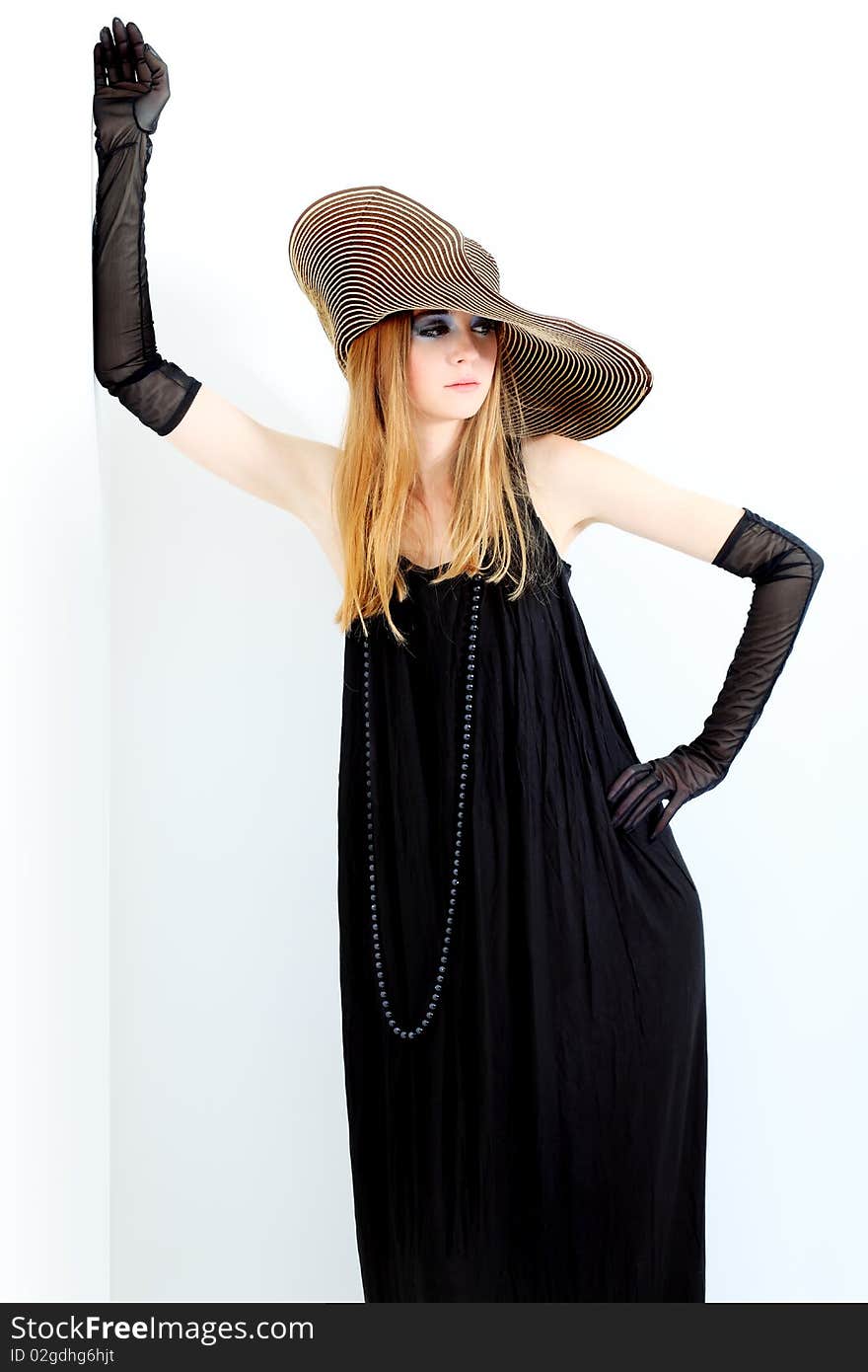 Portrait of a beautiful girl in elegant black dress and a  hat. Portrait of a beautiful girl in elegant black dress and a  hat.