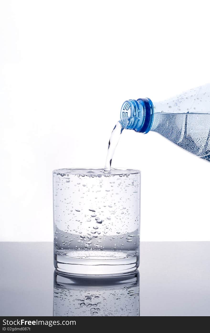 Glass of water being filled from bottle