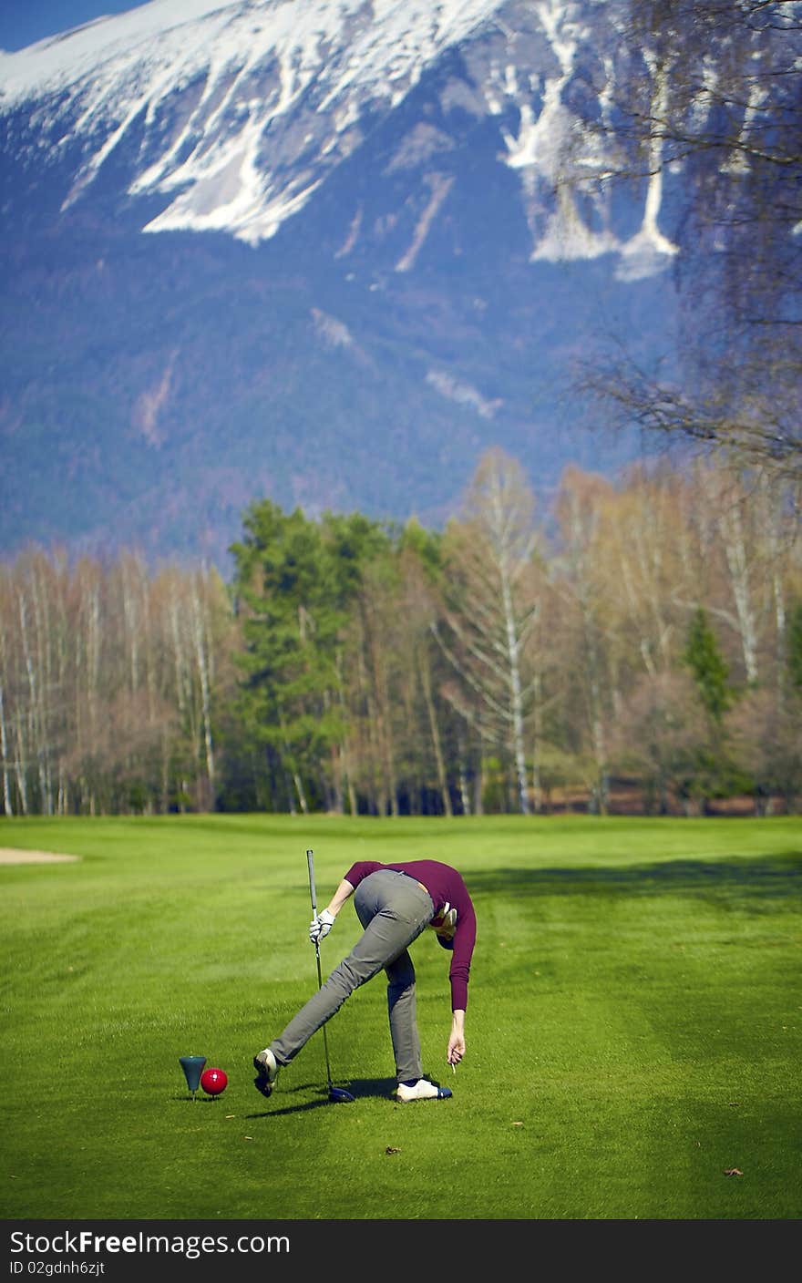 Woman at the golf range preparing golf ball.