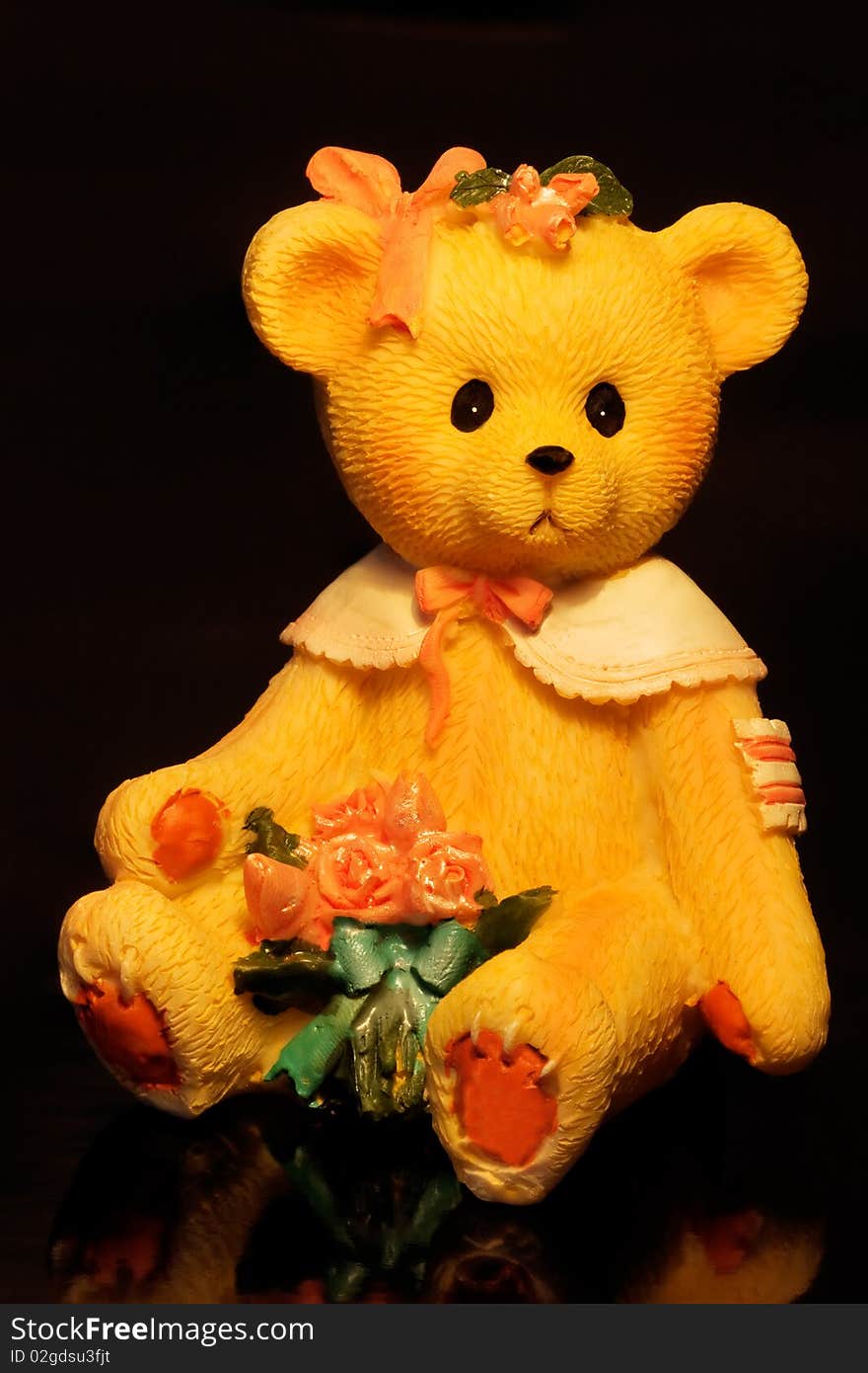 Teddy bear with flowers on a black background