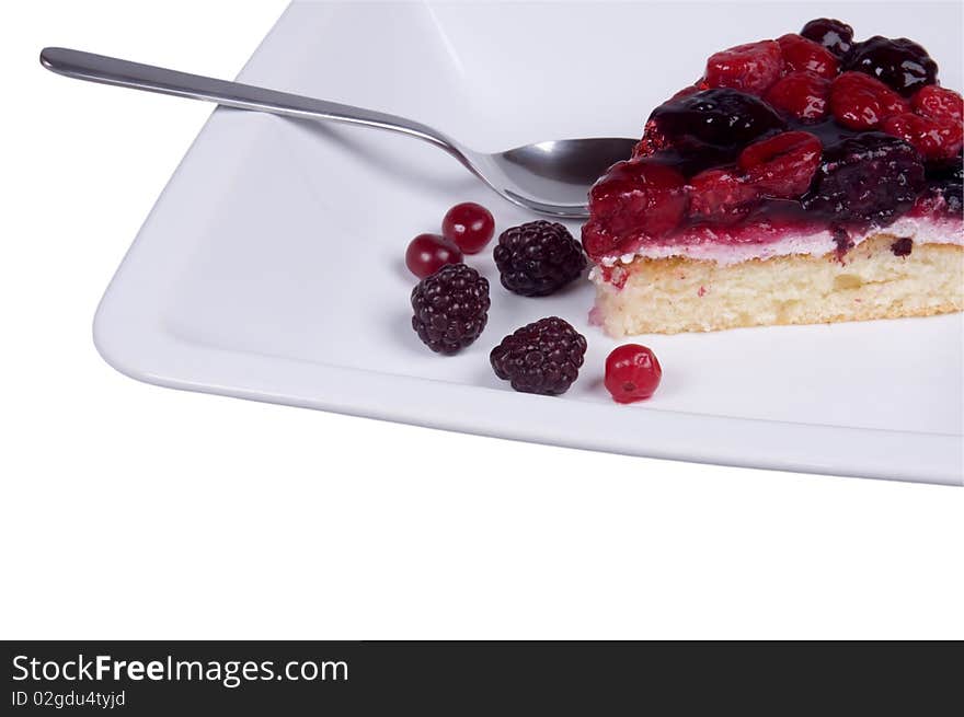 Piece of cake on the plate with a spoon isolated over white