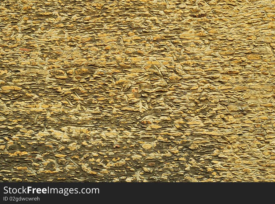 Yellow old wall from stones on the street