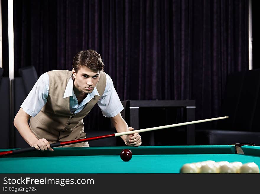 The young attractive well dressed man plays billiards. The young attractive well dressed man plays billiards