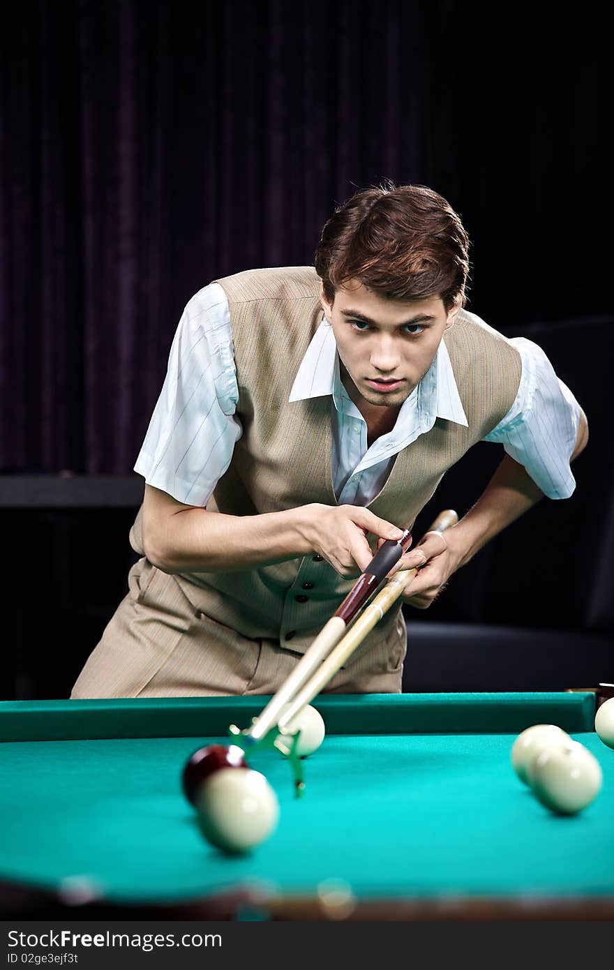 The young attractive well dressed man plays billiards. The young attractive well dressed man plays billiards