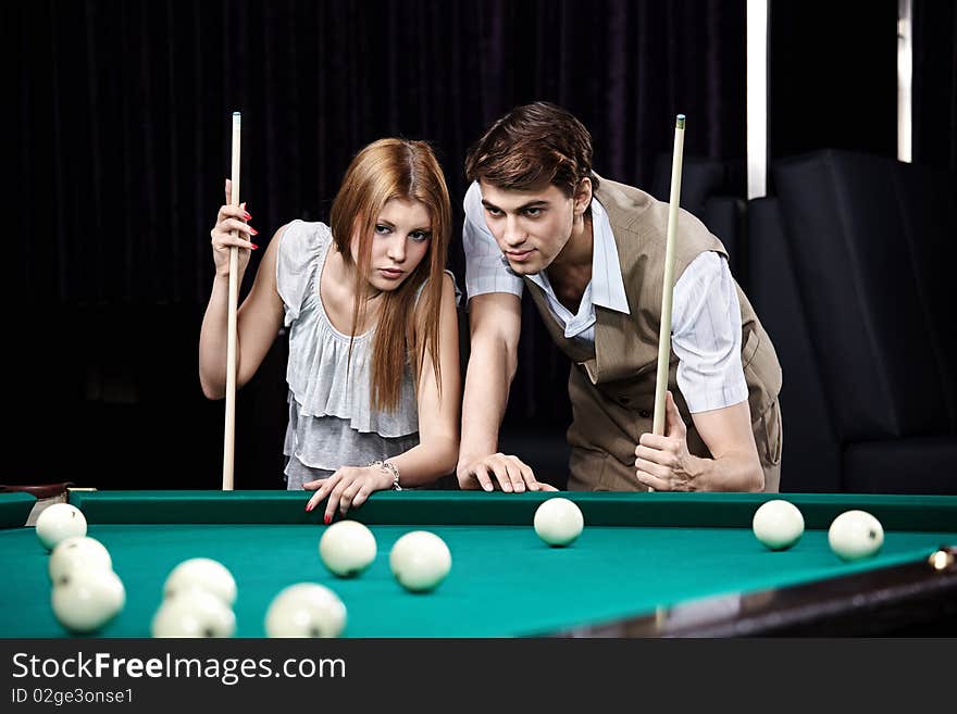 Young man and the woman play billiards. Young man and the woman play billiards