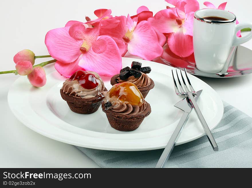 Fruit tarts on the white plate, espresso and orchid. Fruit tarts on the white plate, espresso and orchid.