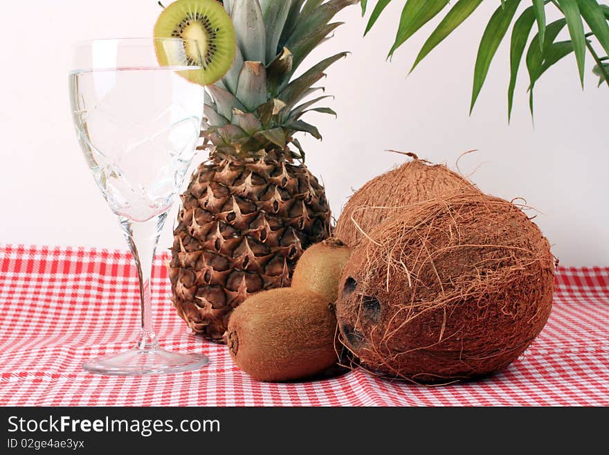 Pineapple, cocos, kiwi, and a glass of mineral water. Pineapple, cocos, kiwi, and a glass of mineral water