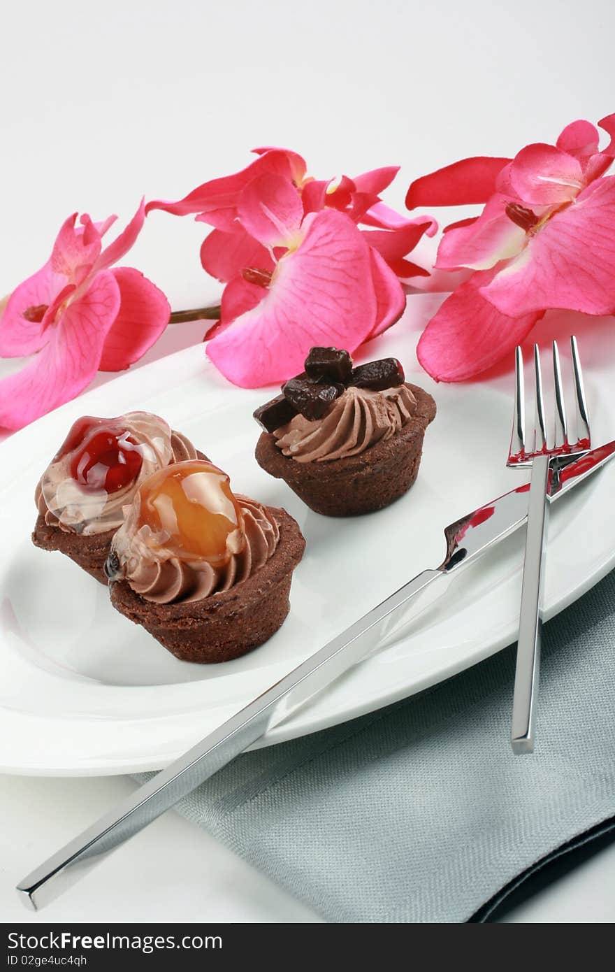 Fruit tarts on the white plate, espresso and pink orchid. Fruit tarts on the white plate, espresso and pink orchid.