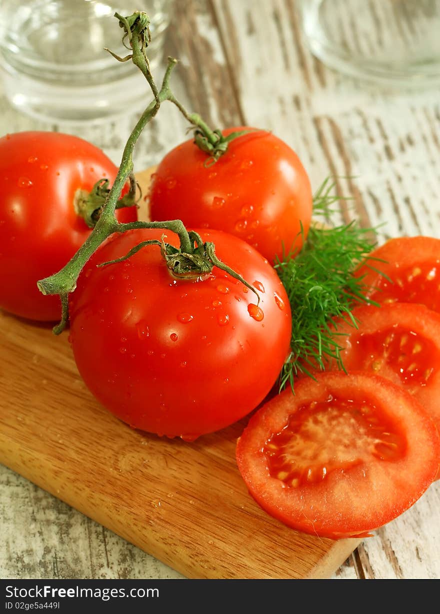 fresh tomatoes with water drops on wooden