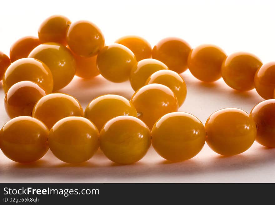 Amber chaplet being shoot in macro with sparkles of light on the beads isolated on the white background. Amber chaplet being shoot in macro with sparkles of light on the beads isolated on the white background