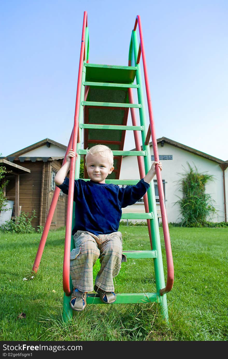 The boy sitting on a ladder. The boy sitting on a ladder.