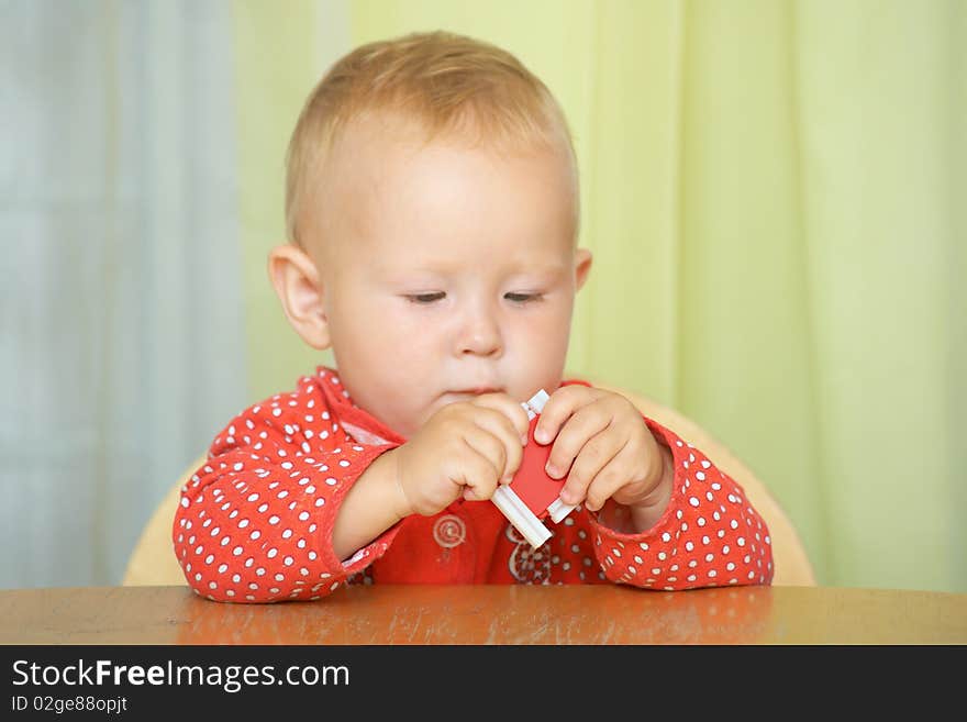 A small child plays with the constructor, sitting at the table. Focus on the hands. Shallow DOF.