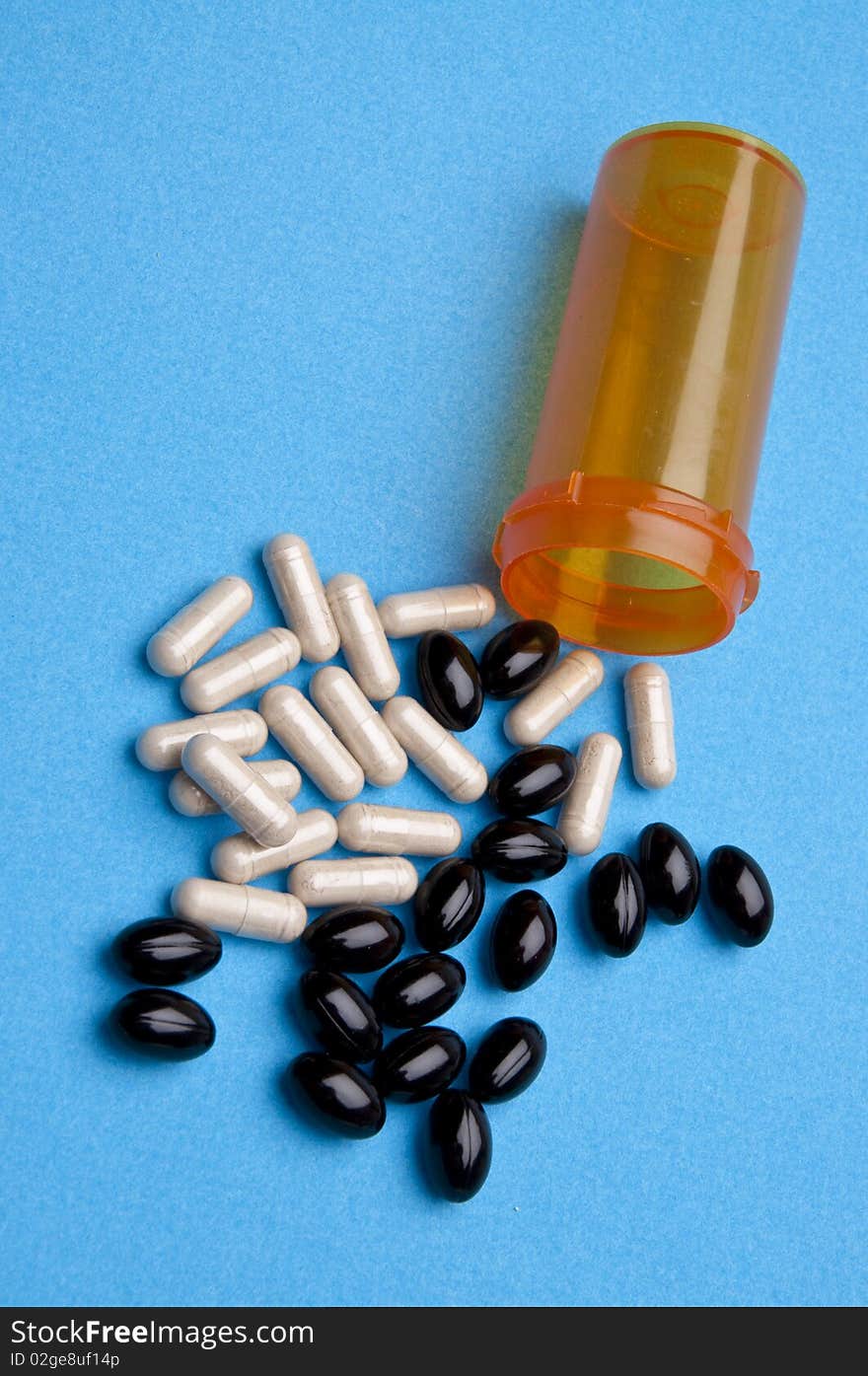 Pills spilling out of an orange prescription bottle on a vibrant background.