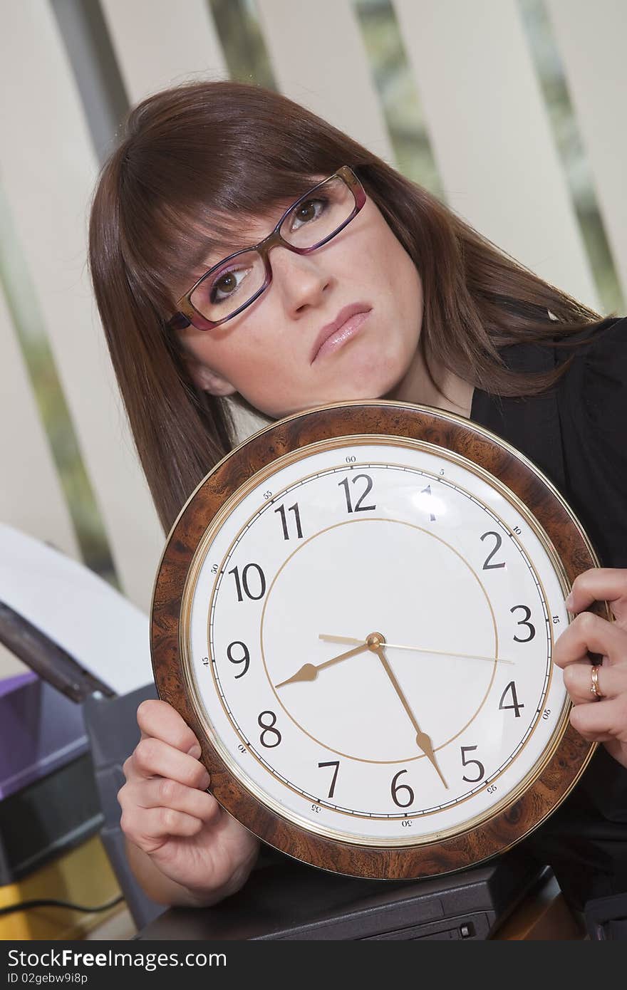 Unhappy woman holding big watch