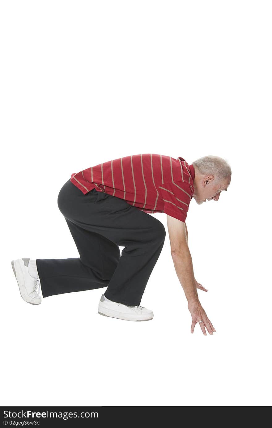 Old man in sportswear in ready position for starting a sprint. Active and fit senior isolated on white. Old man in sportswear in ready position for starting a sprint. Active and fit senior isolated on white.