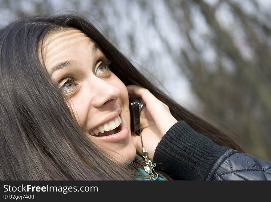 Young beautiful woman on the phone in the park. Young beautiful woman on the phone in the park