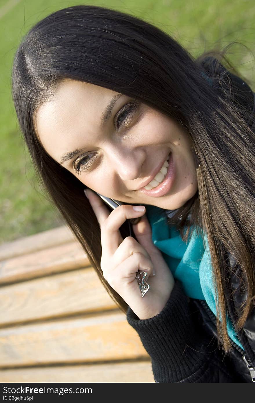 Young beautiful woman on the phone in the park. Young beautiful woman on the phone in the park